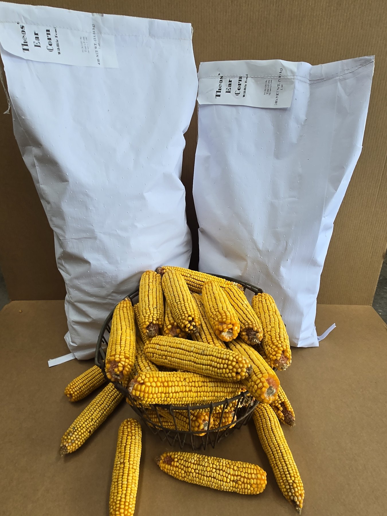 Theo's Farm 20 pound and 40 pound bags of whole ear corn with cleaned ears in front